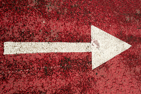 Red asphalt bike path with a white arrow symbol. City infrastructure concepts