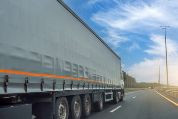 Truck long tilt curtain side trailer transportation on the road day blue sky.