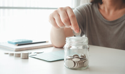 Piggy bank savings. hand put money coin into piggy for saving money wealth. hand holding coins...