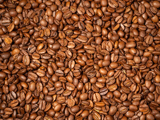 Background from roasted coffee beans. Scattered coffee beans. Coffee beans close up.