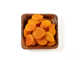 Wooden bowl of dried apricots on a white background, selective focus. Dried apricots close up.