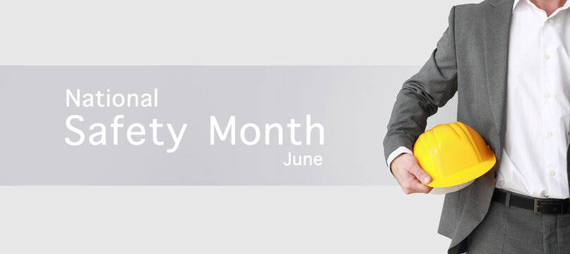 Banner for National Safety Month with male engineer holding hardhat - Powered by Adobe
