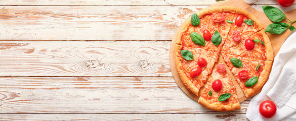 Obraz na płótnie Canvas Tasty cut pizza margarita on light wooden background with space for text, top view