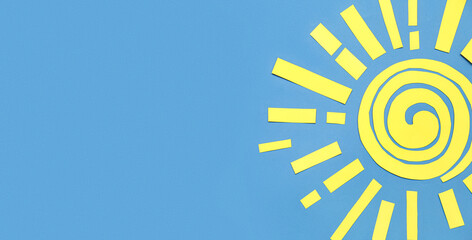Sun made of paper on blue background with space for text