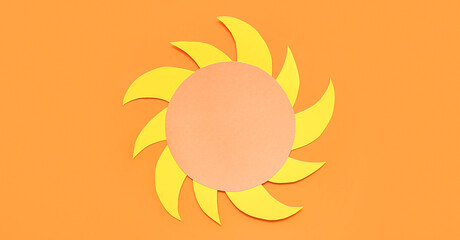 Sun made of paper on orange background