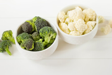 fresh raw broccoli and cauliflower in white cups on the table close-up. background with broccoli and cauliflower.