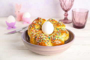 Bowl with tasty Italian Easter bread on light wooden table