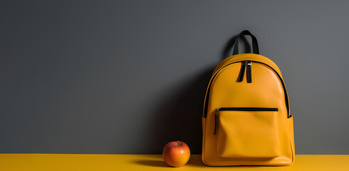 Back to school banner. Bright yellow backpack with apple on grey background with copy space. AI generative
