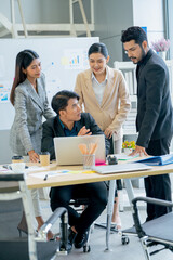 Vertical image of group of Asian young business man and woman discuss about the project in office with day light.