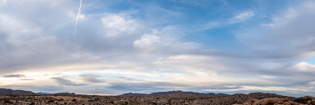 Panoramic landscape views in the Joshua Tree National Park desert during day time with rocks, trees, flat, boulder landscape. Tourist area, popular, camping, camp, road trip, California view.