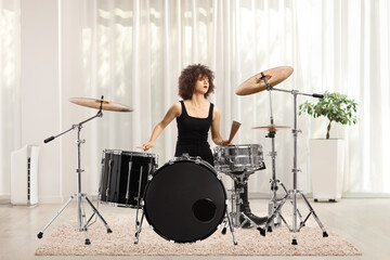 Fototapeta na wymiar Young female musician practicing drums