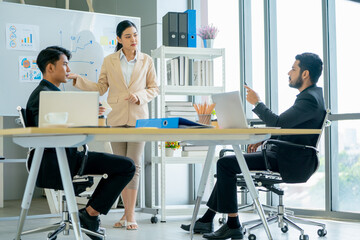 Asian manager ask and discuss with pretty business woman who present the project on board in the office with day light.