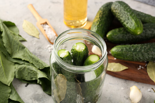 Jar with fresh cucumbers for preservation on grunge background, closeup