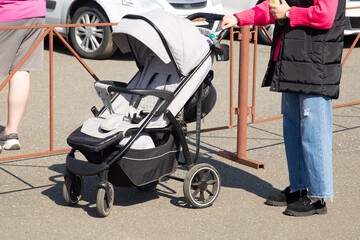 A woman with a baby carriage on a city street.Walking with small children.