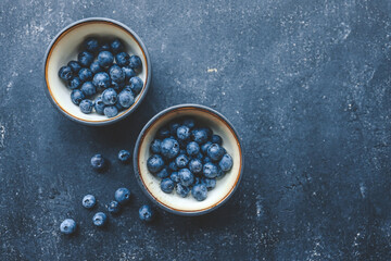 Fresh juicy blueberries in plates on a dark background top view