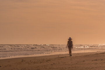 Fototapeta na wymiar Woman relaxing while walking alone on the beach.