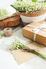 Festive concept, lily of the valley bouquet, gift box and letter