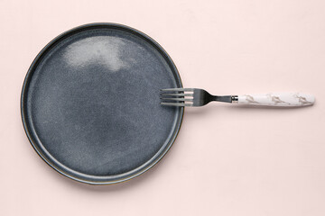 Plate with stainless steel fork on white background