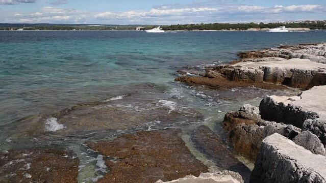 Rocky Shore in Brionian Island Jerolim in Croatia. Stony Beach with Adriatic Sea in Brijuni National Park during Summer Day.