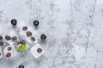 Fresh blueberry frozen in ice cubes on grunge background
