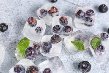 Fresh blueberry frozen in ice cubes on grunge background