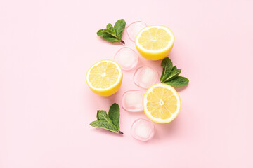 Slices of ripe lemon with mint and ice cubes on pink background