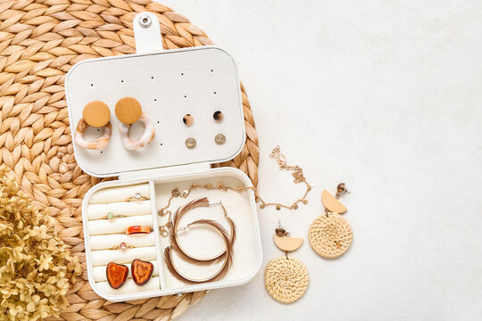 Wicker mat with organizer and stylish jewelry on white background
