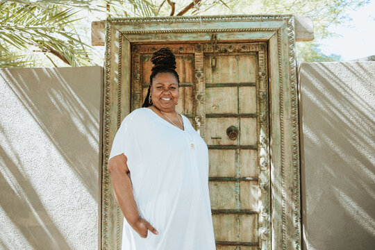 plus size Afro Latinx Haitian American woman standing outside bohemian door