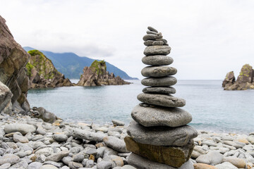 Pebble tower balance harmony stones arrangement on sea beach coastline