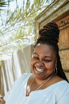 portrait of a plus size woman smiling outside with a top knot