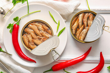 Plate of canned smoked sprats with parsley on white wooden  background