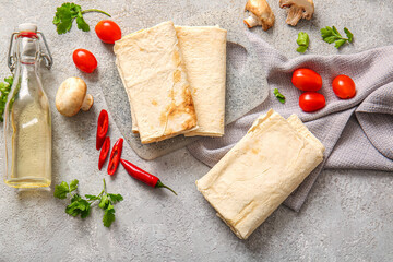 Board with lavash and fresh vegetables on grey background