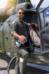 A young military pilot poses next to his aircraft