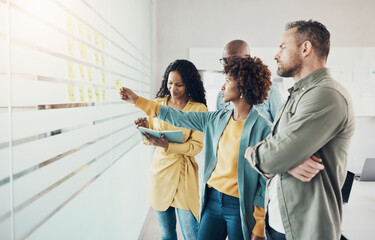 Diverse businesspeople using adhesive notes during an office brainstorming session