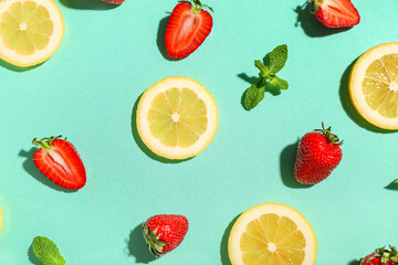 Fresh strawberries with lemon and mint on turquoise background