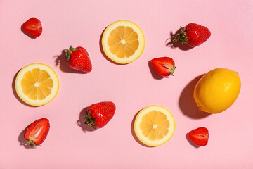 Fresh strawberries and lemons on pink background