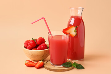 Bottle and glass of tasty strawberry juice on orange background