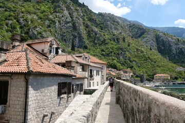 Fototapeta na wymiar Fortress wall in Kotor, Montenegro. Kotor is a beautiful historic city on the Unesco list. Silhouettes of walking people on wall.