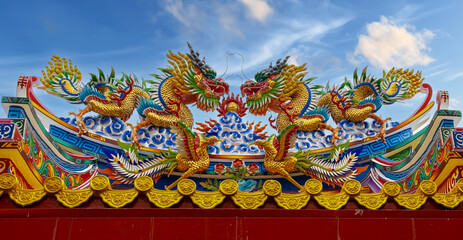 Colourful multicoloured dragon on top of a  temple in Patong Phuket Thailand. beautiful blue green...