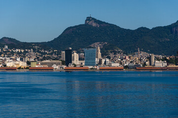 Fototapeta premium Beautiful view of Guanabara Bay in Rio de Janeiro, Brazil with the port, hills, Christ the Redeemer and buildings in the background. Beautiful landscape and hill with the sea. Sunny day