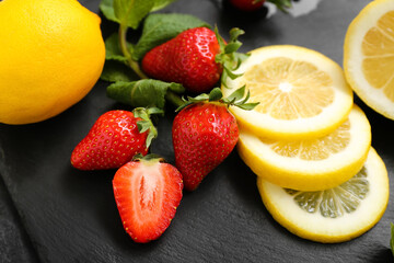 Fototapeta na wymiar Ripe strawberry, lemon slices and mint on dark background, closeup