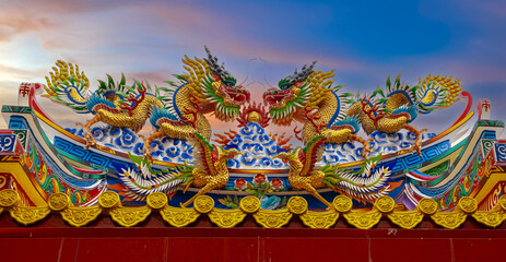 Colourful multicoloured dragon on top of a  temple in Patong Phuket Thailand. beautiful blue green red of the scale dragons