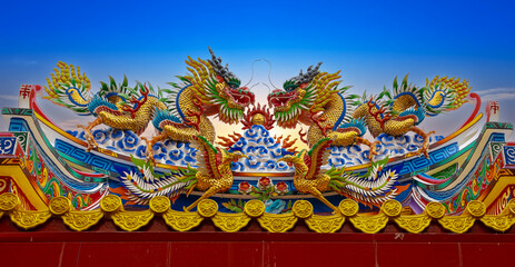 Colourful multicoloured dragon on top of a  temple in Patong Phuket Thailand. beautiful blue green red of the scale dragons
