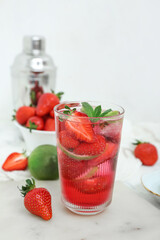 Glass of delicious strawberry mojito on light background, closeup