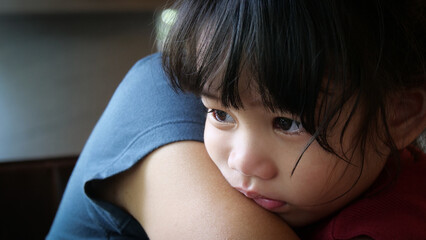 Sad Little Girl is crying in the arms of his mother. Mother and baby with tears in their eyes emotionally embrace. A loving mother hugs and comforts her little daughter. Mom calms child.