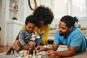 An african american kid is playing with his parents and learning shapes and colors through the...