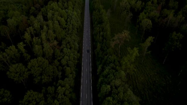 Areal drone footage of car driving in summer forest 