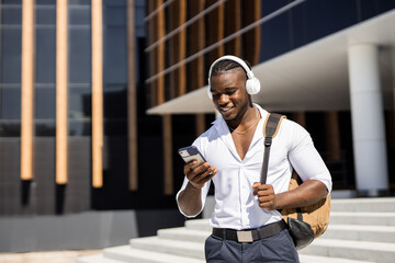 happy student in white shirt with mobile phone and backpack