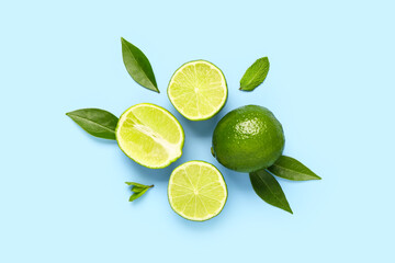 Slices of fresh lime with leaves on blue background