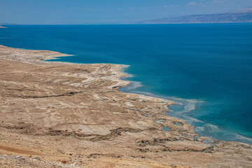 Fototapeta na wymiar Drying of the Dead Sea, located at the lowest point of the Earth. The water recedes, leaving behind a desolate landscape and barren land.